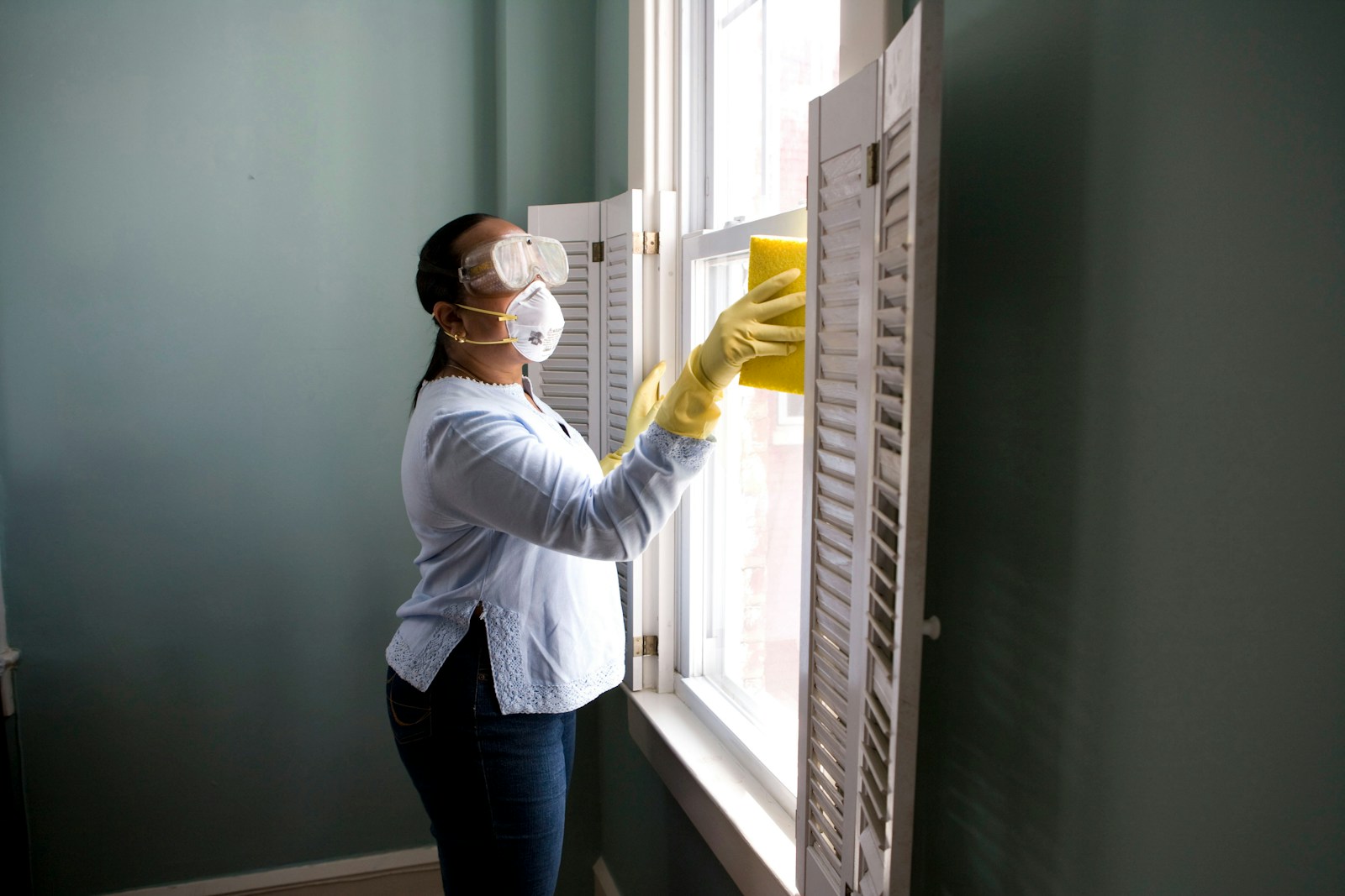 Cleaner carefully wiping a window with a cloth